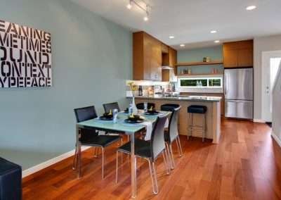 A sleek kitchen and dining area with modern decor, stainless steel appliances, and a glass dining table.