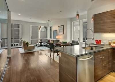 A contemporary kitchen and living area with modern design elements, a large kitchen island, and ample lighting.