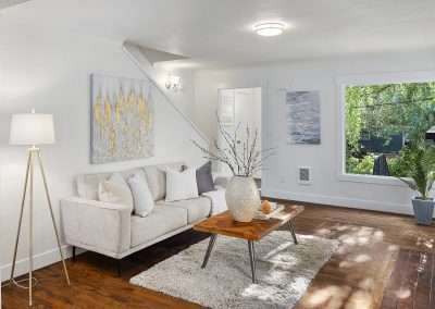 A bright and airy living room with contemporary furniture, a wooden coffee table, and decorative elements