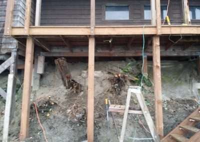 Foundation repair work under a house with tools and materials.