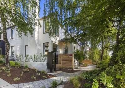 A garden area with various plants and a paved pathway leading to the home's entrance