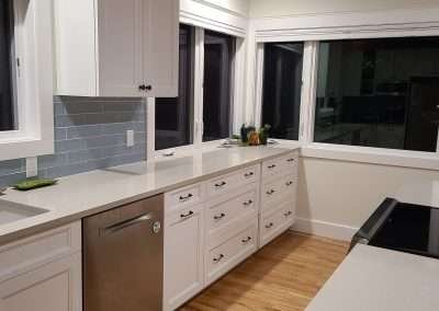 A kitchen featuring multiple white cabinets and drawers, providing ample