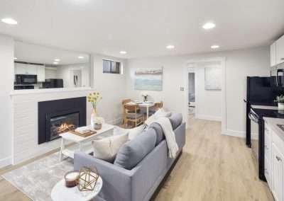 A living area with a sofa, coffee table, and fireplace, featuring a modern, bright design.
