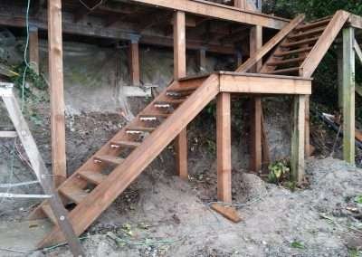 Newly constructed wooden staircase under a house.
