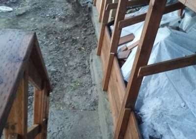 New wooden supports installed under a house for reinforcement.