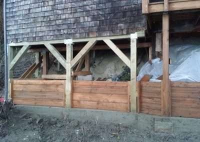Reinforced foundation structure under a house with new supports.