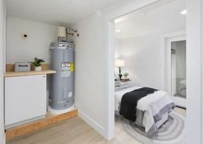 A utility area with a water heater and storage space, next to a bedroom.