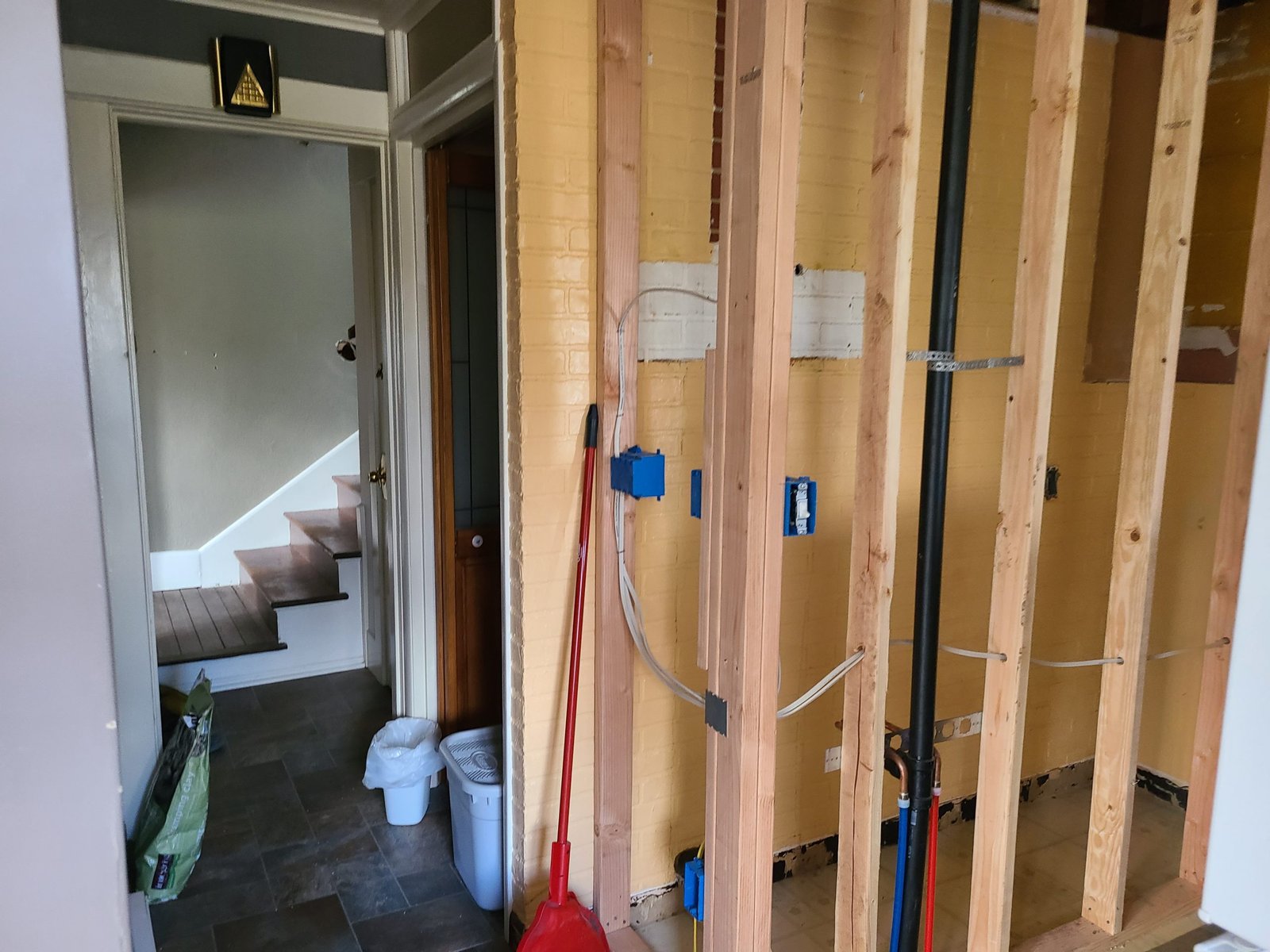 Basement remodeling in progress with exposed wooden framing and electrical wiring.
