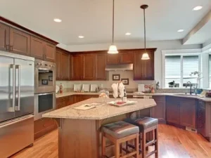 Bellevue 3 Modern open-concept kitchen with wood cabinetry, stainless steel appliances, and hardwood flooring in a Seattle home renovation.