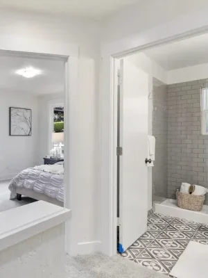 A hallway with built-in cabinets, leading to two bedrooms and a bathroom.