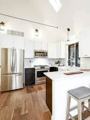 Bright modern kitchen with white cabinetry, stainless steel appliances, and a spacious island in a Seattle home remodel.