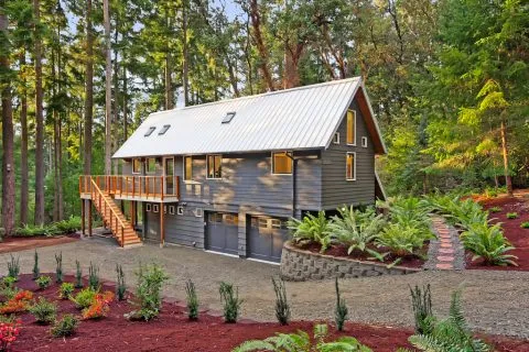 A bright kitchen featuring a long countertop with white cabinets and large windows.