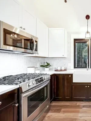 Modern kitchen with a farmhouse sink, stainless steel appliances, and two-tone cabinetry in a Seattle home remodel.