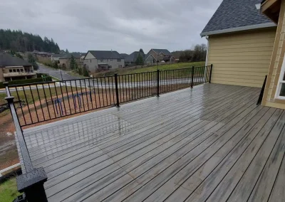 Spacious elevated deck with black metal railing and composite decking, offering a stunning backyard view in Seattle. Designed and built by top-rated deck contractors in Seattle for durability and style.