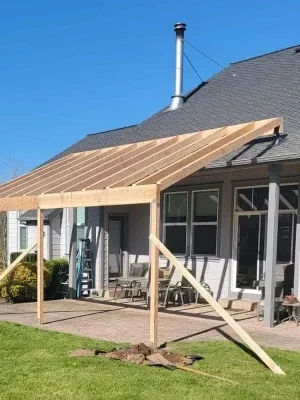 Seattle Home Addition – Patio Expansion by Expert Home Addition Contractors Partially built home addition in Seattle featuring a wooden-framed patio cover extension in a spacious backyard, constructed by experienced home addition builders in Seattle.