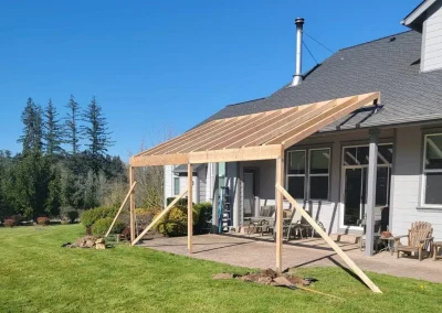 Partially built home addition in Seattle featuring a wooden-framed patio cover extension in a spacious backyard, constructed by experienced home addition builders in Seattle.