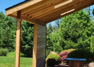 Completed home addition in Seattle featuring a custom-built covered patio with a wooden slatted roof and privacy wall, designed by expert home addition contractors in Seattle.
