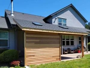 Bellevue 4 Seattle home addition featuring a stylish covered patio with a wooden privacy wall and skylights, designed and built by expert home addition contractors in Seattle.