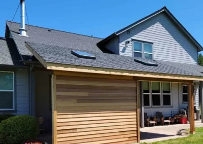 Seattle home addition featuring a stylish covered patio with a wooden privacy wall and skylights, designed and built by expert home addition contractors in Seattle.