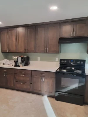 Kitchen remodel with dark wood cabinetry, light countertops, and a black stove in a Seattle home renovation.