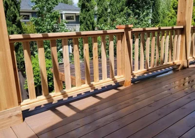 Custom-built wooden pergola over a spacious composite deck with decorative railing, enhancing an outdoor living space in Seattle. Designed by expert deck and patio contractors in Seattle for durability and style
