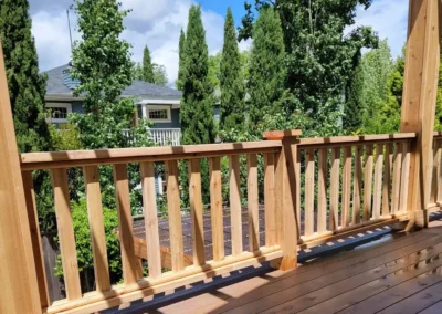 Custom-built wooden pergola over a spacious composite deck with decorative railing, enhancing an outdoor living space in Bellevue. Designed by expert deck and patio contractors in Bellevue for durability and style
