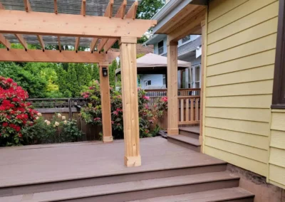 Custom composite deck with a wooden pergola and wide stairs, enhancing the outdoor space of a Bellevue home. Built by expert deck and patio contractors in Bellevue for functionality and aesthetic appeal.