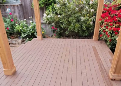 Beautiful wooden pergola with a transparent roof, built over a composite deck in a landscaped Bellevue backyard. Designed by expert patio and deck contractors in Bellevue for a stylish and functional outdoor space.