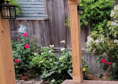 Custom-built wooden pergola with a transparent polycarbonate roof, set on a composite deck in a landscaped Seattle backyard. Designed by expert patio and deck contractors in Seattle for durability and outdoor relaxation.