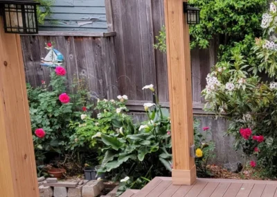 Custom-built wooden pergola with a transparent polycarbonate roof, set on a composite deck in a landscaped Bellevue backyard. Designed by expert patio and deck contractors in Meydenbauer area for durability and outdoor relaxation.