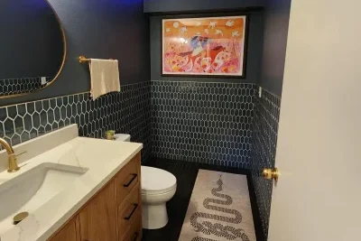 Modern navy blue bathroom remodel in Seattle featuring hexagonal tiles, a floating vanity, and ambient lighting – a project by Elite Remodeling.