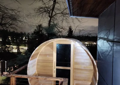Custom-built barrel sauna installation on a Seattle deck, enhancing outdoor relaxation and wellness.