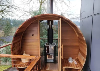 Seattle custom-built barrel sauna installation with wood-fired heater on an outdoor deck.
