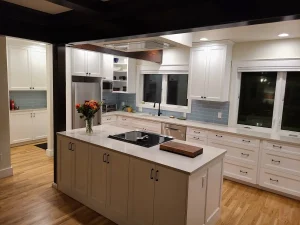 Bellevue 2 Spacious modern kitchen with white cabinetry, large island, and hardwood flooring in a Seattle home remodel.
