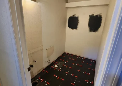 Seattle bathroom remodel in progress, featuring floor tile installation and prepped walls for a modern redesign.