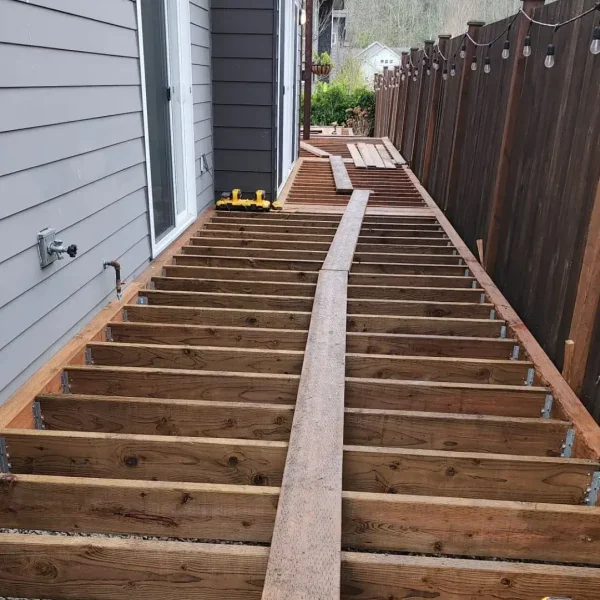 A stylish bathroom with patterned floor tiles, a glass shower, white fixtures, and grey subway tiles