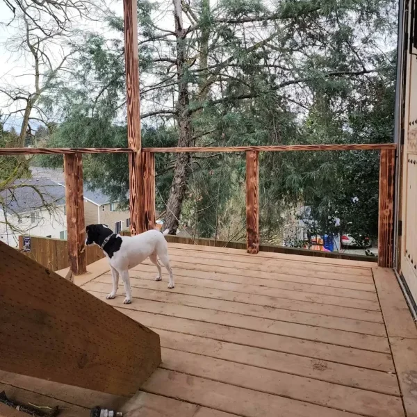 Partially completed elevated wooden deck with unfinished railing, offering a scenic view in a Seattle backyard. Built by expert deck contractors in Seattle for a durable and stylish outdoor space.