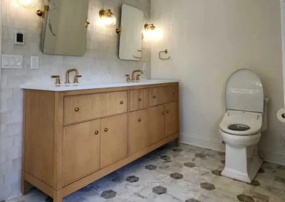 Full view of a white oak bathroom vanity with dual mirrors and integrated lighting.