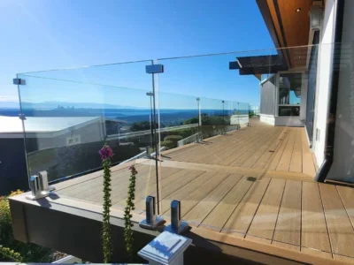 Architectural-Ironwood-deck-construction-with-Glass-Railing-Horizon-Deck- Frameless glass railing panels secured with stainless steel spigots on a luxury composite deck.