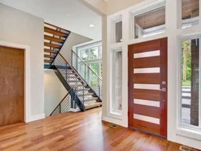 Bride-Trail-Bellevue-Modern-Entryway-with Wooden-Staircase A modern entryway with a wooden staircase and a stylish wooden front door, accented by large windows in Bride Trail Bellevue.