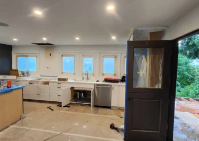 Mercer Island kitchen under construction with white lower cabinets, tape on surfaces, and unfinished flooring.