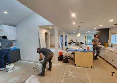 Remodeling crew installing cabinets and tile backsplash in a Mercer Island kitchen under active construction.