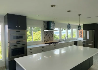 Modern wet bar with two-tone cabinets, wine cooler, mosaic backsplash, and marble-veined tile floor.