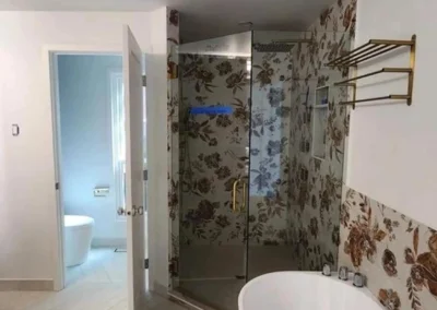Bespoke Mercer Island bathroom remodel featuring a freestanding soaking tub, chevron tile flooring, and a frameless glass shower enclosure with patterned tile work and brushed gold hardware.