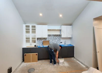 Contractor installing a kitchen beverage station with dual-tone cabinets and mosaic backsplash on Mercer Island.