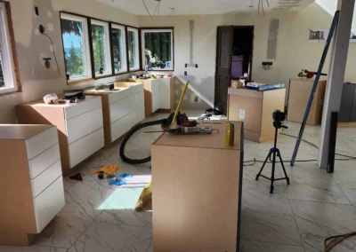 Kitchen mid-remodel showing cabinet boxes being installed, marble tile flooring, and tools on Mercer Island.