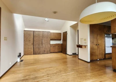 Old wood cabinets, wood flooring, and a dated light fixture before the Mercer Island remodel.