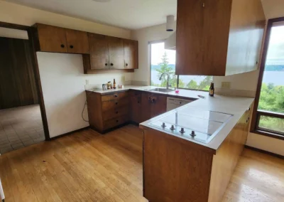 Old wood kitchen with laminate countertops and a view of the water before a Mercer Island remodel.