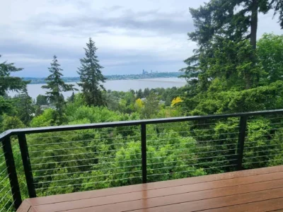 mercer-island-custom-deck-with-lake-view-toward-Seattle Mercer Island custom deck framed by evergreen trees with a territorial view of Lake Washington and Seattle.