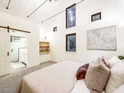 redmond-bedroom-remodel-ensuite-barn-door-vaulted-ceiling Remodeled Redmond bedroom with a vaulted ceiling, sliding barn door, and ensuite bathroom with a tiled walk-in shower